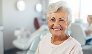 Happy older woman sitting in dental office