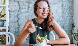 Woman smiling while eating healthy meal