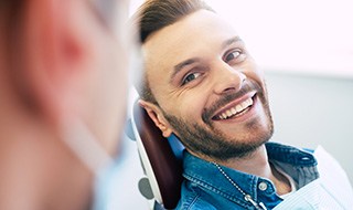 Man smiling while looking at dentist in treatment chair