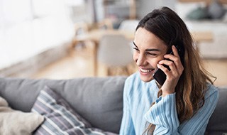 Woman smiling while talking on phone at home